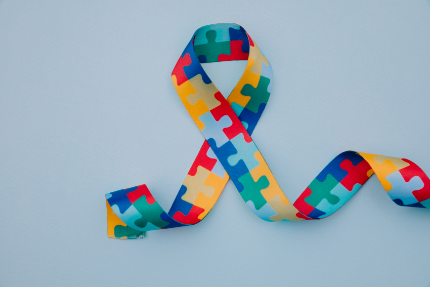 world-autism-awareness-pride-day-with-puzzle-pattern-ribbon-blue-background